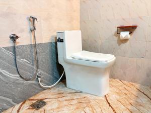 a white toilet in a bathroom with a shower at Saralalayam in Varkala +40 photos