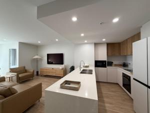 una cucina e un soggiorno con un divano e un tavolo di SERENITY ON SECOND Unit 307-SERENITY a Maroochydore