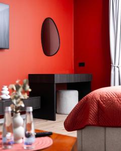 a living room with a red wall and a mirror at Erika's Apartments in Pristina