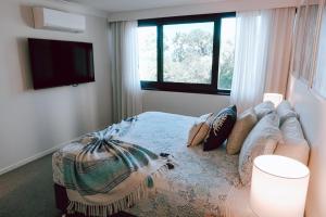 a bedroom with a bed with a couch and a tv at Seven @Aquarius in Cairns +17 photos