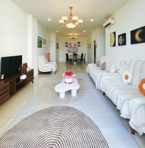 ein Wohnzimmer mit weißen Sofas und einem Fernseher in der Unterkunft 涵舍homestay in Sibu