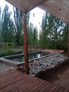 una piscina in un cortile con terrazza in legno di Container House a Cacheuta