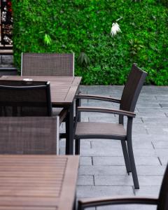 two wooden tables and chairs on a patio at Erika's Apartments in Pristina