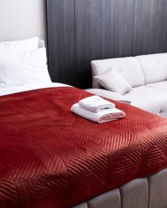 a bed with a red blanket and a couch at Erika's Apartments in Pristina +135 photos