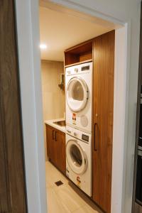 a laundry room with a washer and dryer at Seven @Aquarius in Cairns