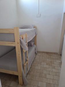 een kamer met 2 stapelbedden en een tegelvloer bij Complejo cardiel in Mar del Plata