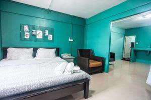- une chambre avec un lit et un mur bleu dans l'établissement Hello House, à Krabi