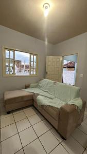 un letto in una camera da letto con due finestre di Microcasa Nascimento a Imbituba