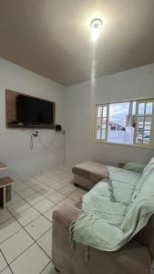 una camera da letto con un letto e una TV a schermo piatto di Microcasa Nascimento a Imbituba