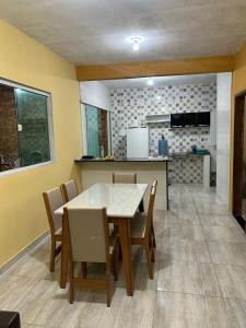 eine Küche und ein Esszimmer mit Tisch und Stühlen in der Unterkunft casa em peroba in Maragogi