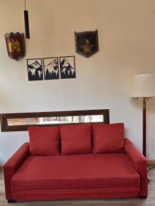 Klatt Haus, Golf y Polo的客厅里一张红色的沙发,墙上挂着照片