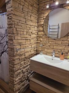 een badkamer met een witte wastafel en een stenen muur bij Klatt Haus 