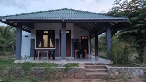 a small house with a gazebo at Wild Night Hostel Sigiriya in Sigiriya