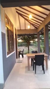 a patio with a wooden table and chairs on it at Wild Night Hostel Sigiriya in Sigiriya