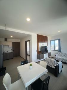 un soggiorno con un tavolo bianco e un letto di Suite Miramar 4 vista lateral al mar a Playas