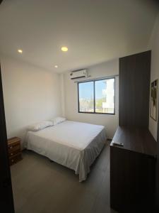 una camera da letto con un letto bianco e una finestra di Suite Miramar 4 vista lateral al mar a Playas Altre 9 foto