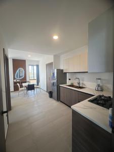 una cucina con armadi bianchi e una sala da pranzo di Suite Miramar 4 vista lateral al mar a Playas