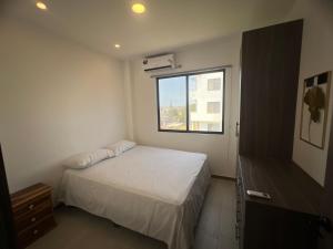 una piccola camera da letto con un letto e una finestra di Suite Miramar 4 vista lateral al mar a Playas