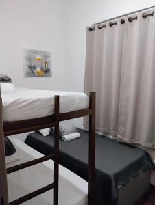 een kamer met 2 stapelbedden en een gordijn bij Pousada do Seu Souza in Belo Horizonte +3 foto's