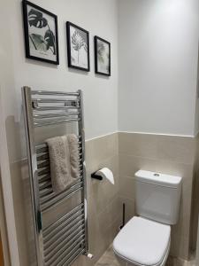 een badkamer met een toilet en drie foto's aan de muur bij Modern Refurbished Apt in Stevenage Town Centre in Stevenage +19 foto's
