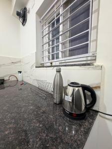 a tea kettle sitting on a counter under a window at RS Rooftop in Hyderabad