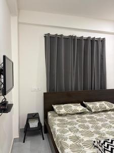 a bedroom with a bed with a gray curtain at RS Rooftop in Hyderabad +16 photos