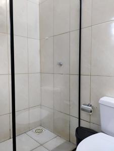 een douche met een glazen deur in een badkamer bij Pousada do Seu Souza in Belo Horizonte