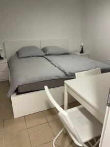 ein weißes Schlafzimmer mit einem Bett, einem Schreibtisch und einem weißen Schreibtisch in der Unterkunft Haus Zum Bacchus in Mainz