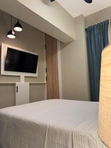 een slaapkamer met een bed en een flatscreen-tv bij Boca Chica Luxury apartment in Boca Chica