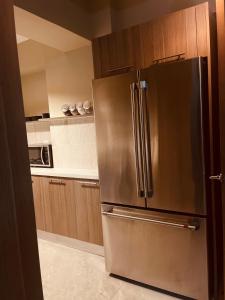 een roestvrijstalen koelkast in een keuken met houten kasten bij Boca Chica Luxury apartment in Boca Chica