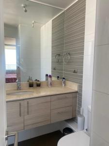 a bathroom with a sink and a mirror and a toilet at Dpto 2 dormitorios vista al mar in Concón +14 photos