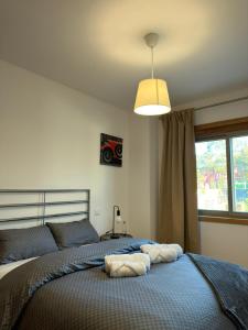 a bedroom with a bed with a blue comforter and a window at Alojamento Local Pando in Vila do Conde