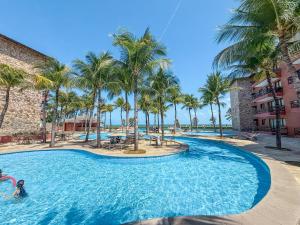 a pool at a resort with palm trees at Kariri beach apt 427 Praia do Cumbuco in Cumbuco