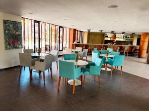 a dining room with tables and chairs and windows at Kariri beach apt 427 Praia do Cumbuco in Cumbuco