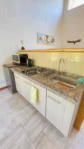 a kitchen counter with a sink and a stove at Los Nenúfares in Lago Puelo