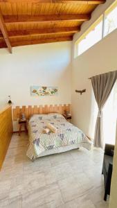 a bedroom with a bed and a large window at Los Nenúfares in Lago Puelo