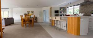 a kitchen with white cabinets and a table and chairs at Gem bed and breakfast in Christchurch +31 photos
