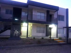 een appartementencomplex met een balkon 's nachts bij Complejo Área Terrazas in La Cieneguita