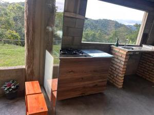 a kitchen with a stove and a large window at Encanto da Paz in Miracatu