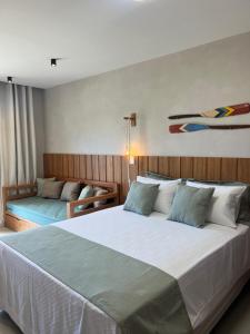 a bedroom with a large white bed and a couch at Sol de Marau - Taipu de Fora - próximo das piscinas naturais in Marau +33 photos