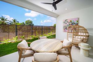 a room with a table and chairs and a fence at Elegant LUX 2BR 3mins to Beach Pool & Deck in Saint James