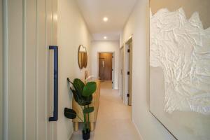 a hallway with a vase with a plant on a wall at Elegant LUX 2BR 3mins to Beach Pool & Deck in Saint James