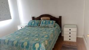 een slaapkamer met een bed met een groene deken en blauwe kussens bij Complejo Área Terrazas in La Cieneguita