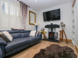 een woonkamer met een blauwe bank en een open haard bij Park View in Ambleside