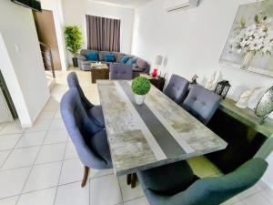 a dining room with a table and blue chairs at Residencia Mediterráneo con Casa Club y Alberca in La Paz