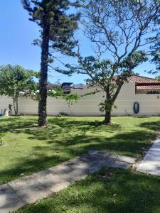 two trees in a yard next to a white wall at Mansion in the mountains in Teresópolis