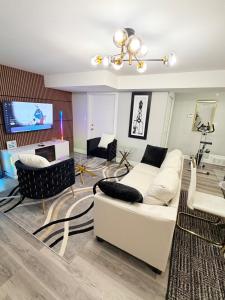 een woonkamer met een witte bank en een tv bij True Haven Deluxe in Prince George