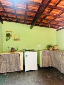 a room with a green wall and a table with curtains at Apartamento 4 quartos Contagem in Contagem