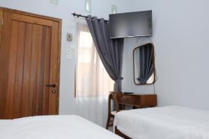 ein Schlafzimmer mit zwei Betten, einer Kommode und einem Spiegel in der Unterkunft Shoreside - Bukit Asri in Jepara