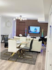 a living room with a table and chairs and a tv at True Haven Deluxe in Prince George +81 photos